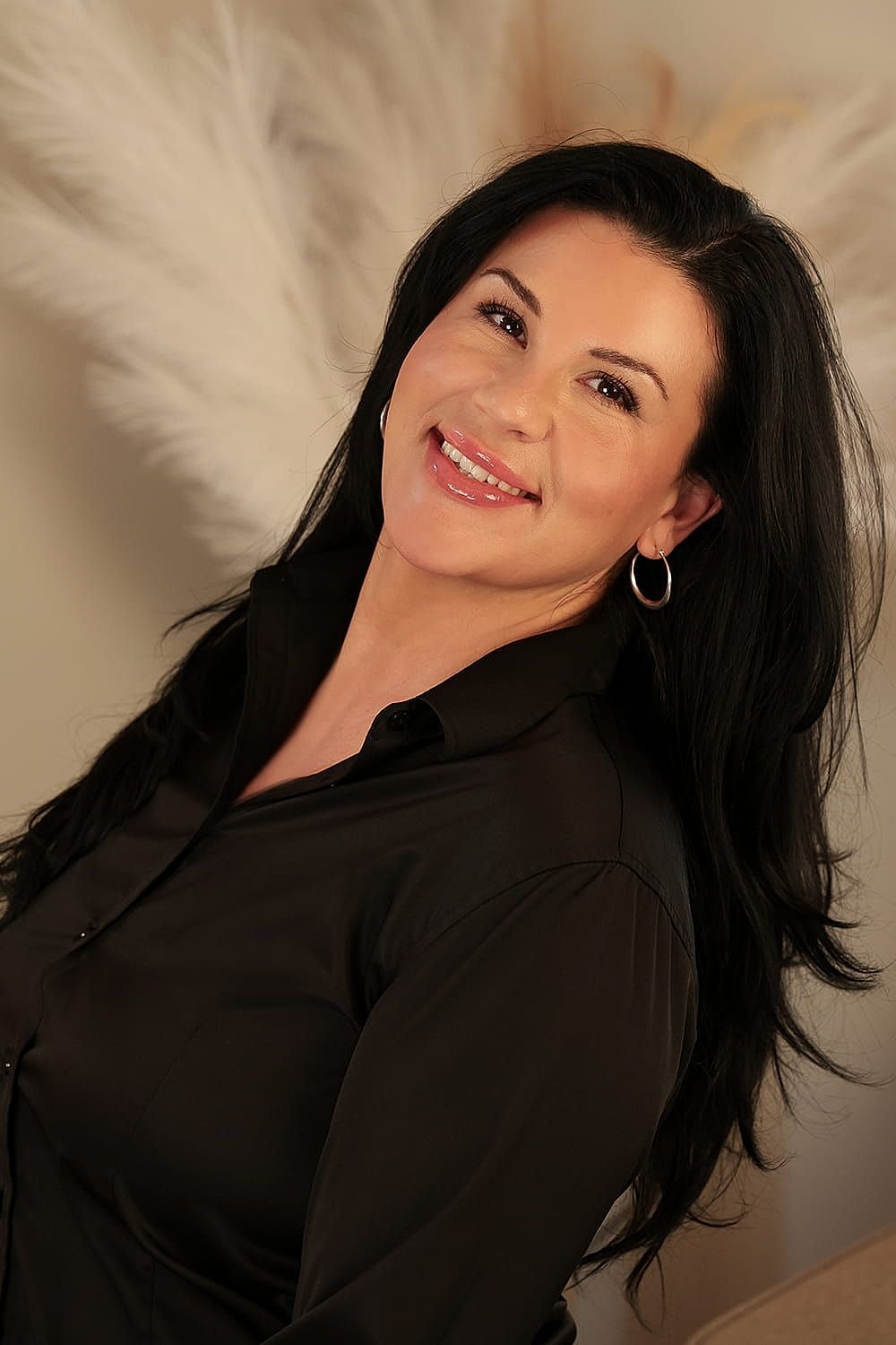 Woman in professional attire smiling warmly.