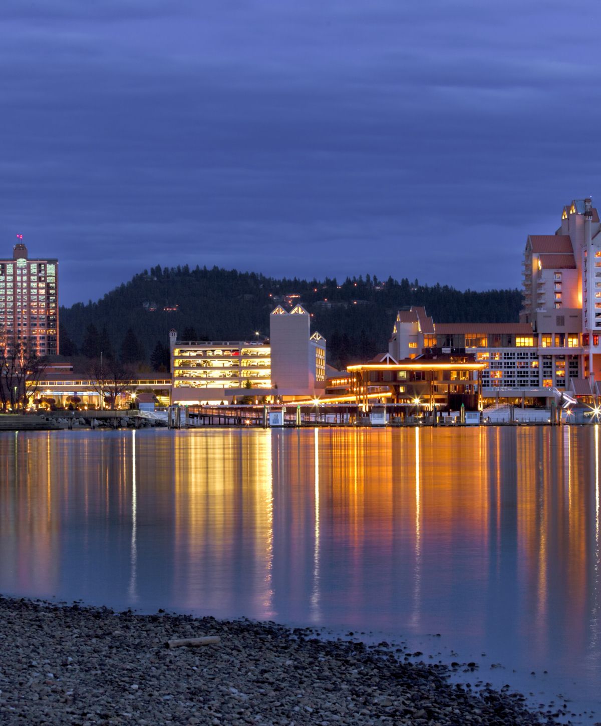 City skyline reflecting on calm water at dusk.