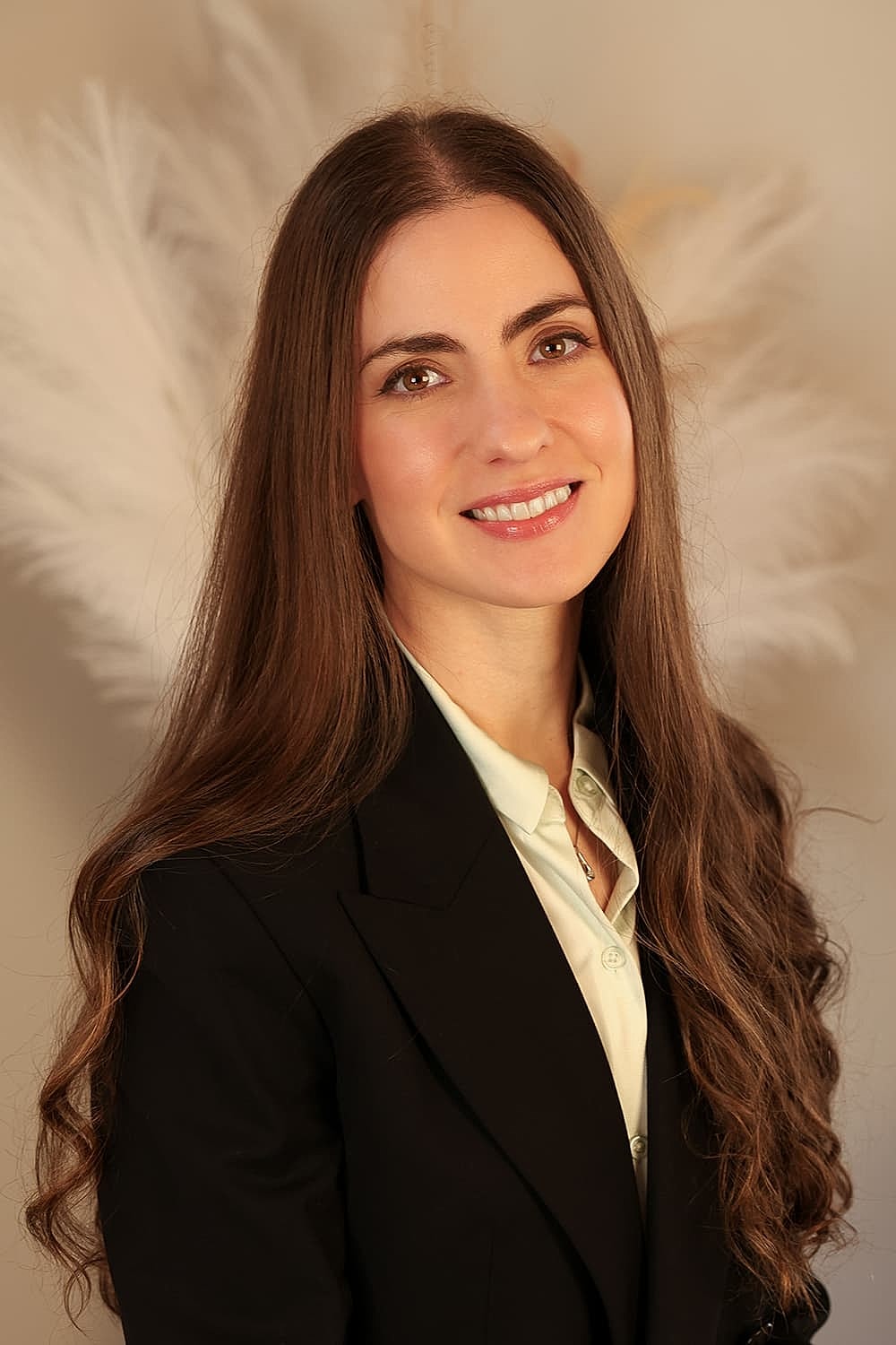 Woman in professional attire smiling warmly.