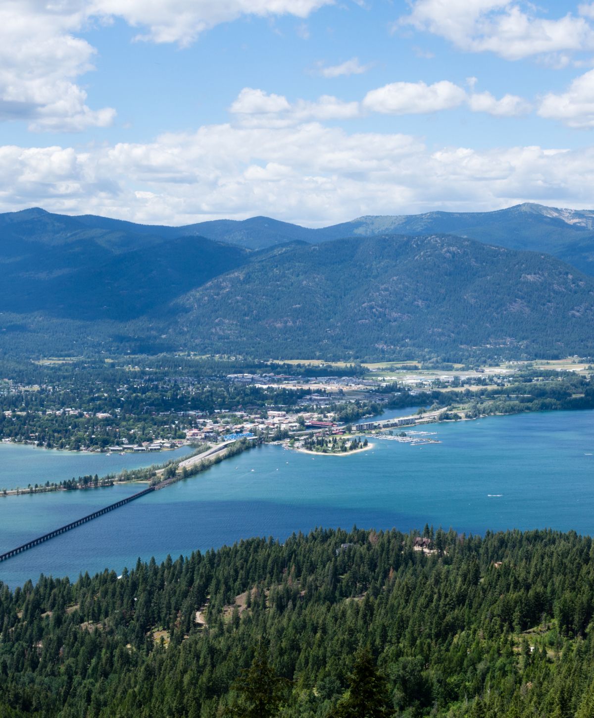 Aerial view of lake, mountains, and town.