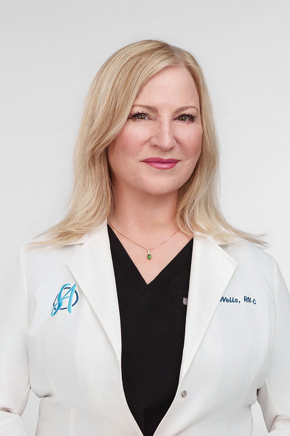 Medical professional in white coat, smiling confidently.