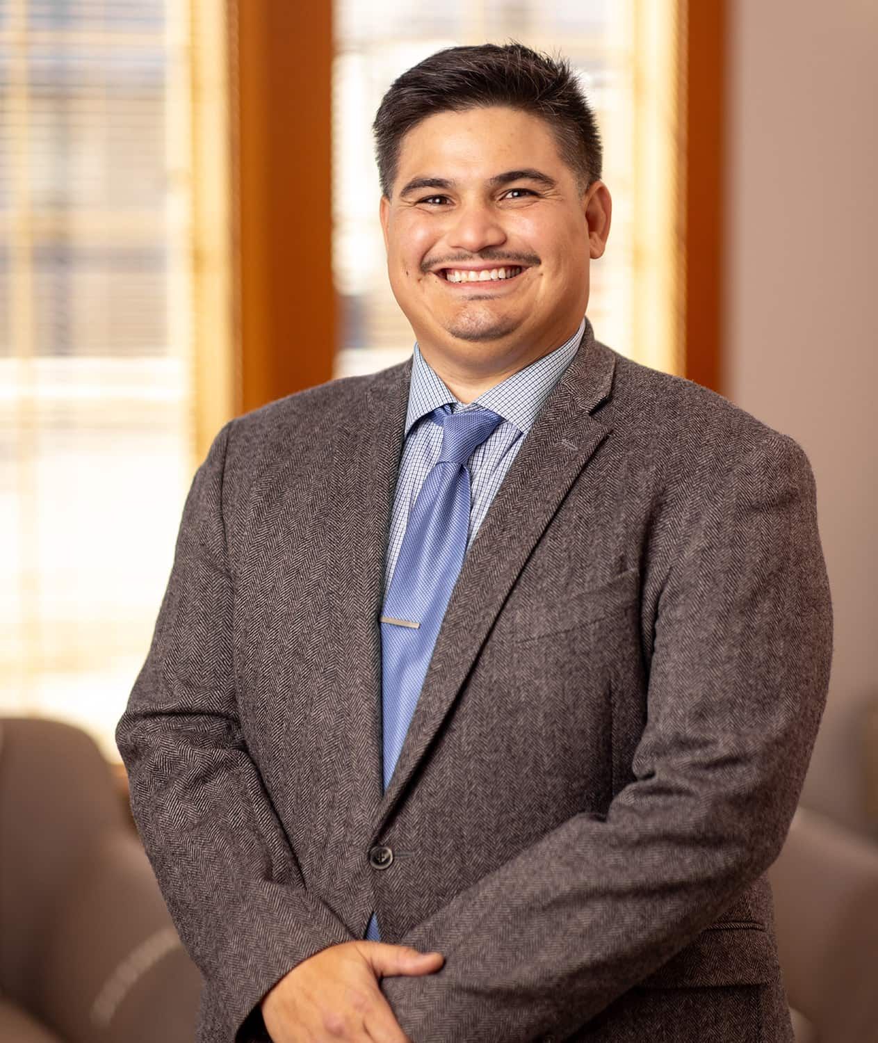 Woman in professional attire smiling warmly.