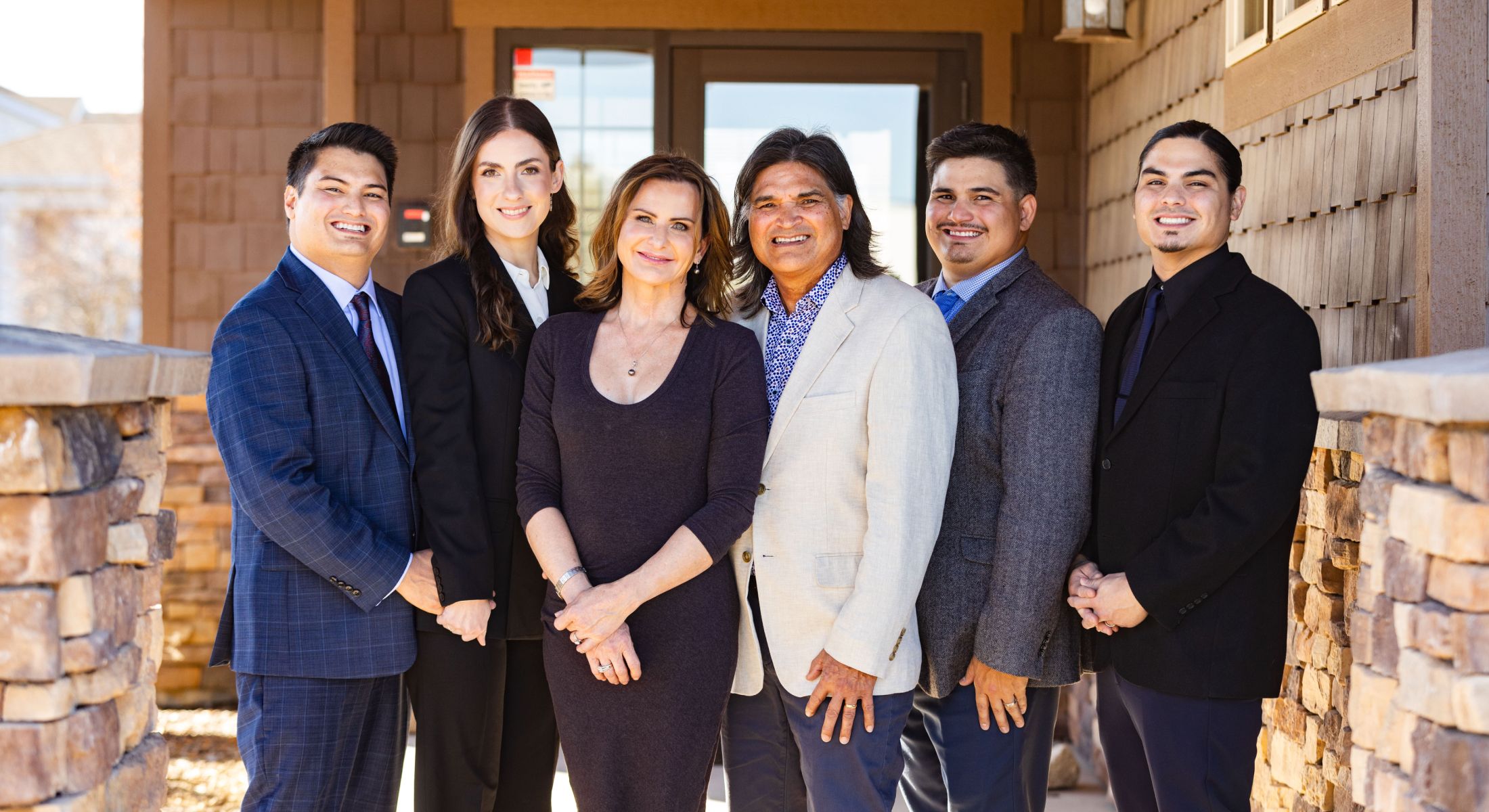 Group portrait of six professionals outdoors.
