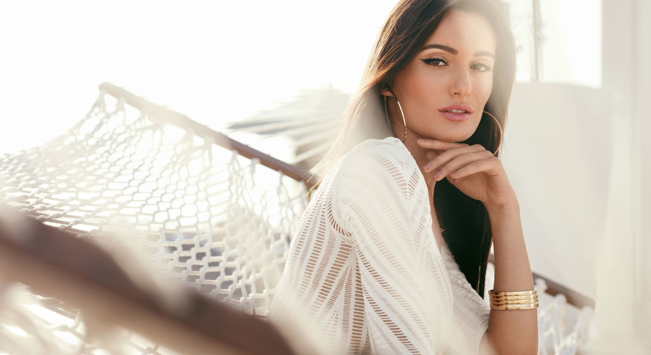 Woman relaxing in hammock with natural lighting.