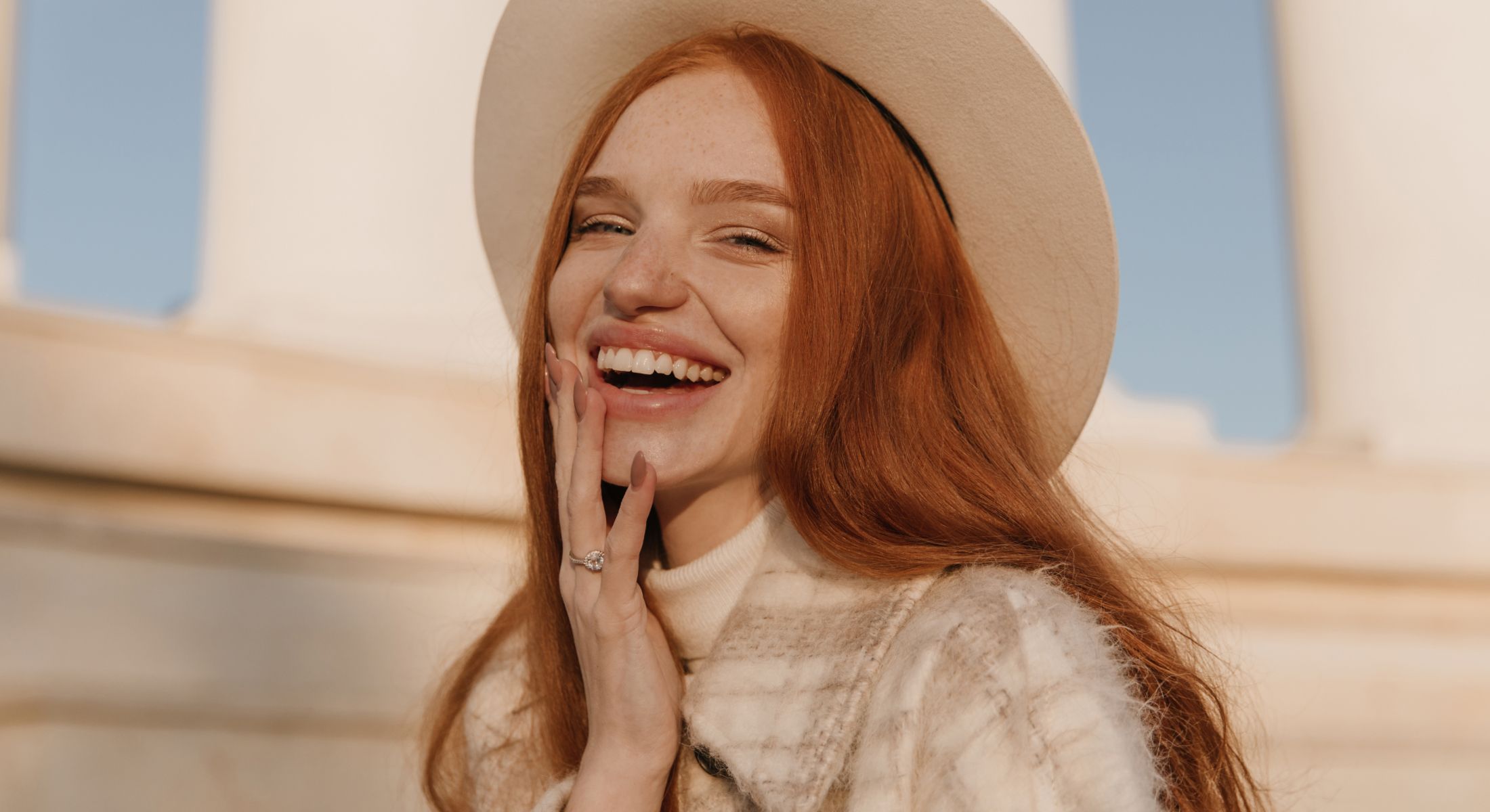 Smiling woman with red hair and hat.